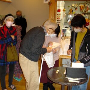 複数の入居者と職員が一緒に室内活動を行っている様子。クリスマス装飾が見られます。